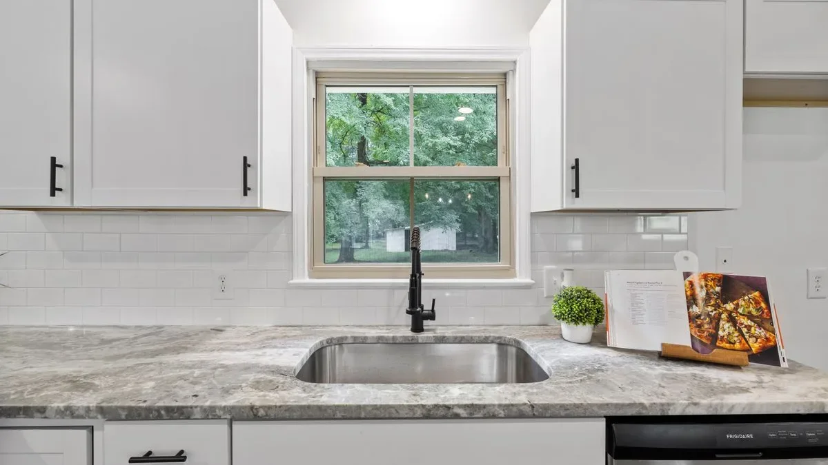 Kraus Standart PRO undermount utility sink integrated into a quartz countertop with matte black faucet